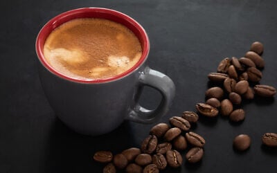 Illustrative image of a cup of coffee against the background of roasted coffee beans (Lenti Hill; iStock by Getty Images)