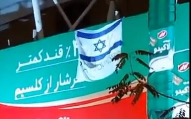 An Israeli flag and sign reading 'Thank you, Mossad' in a Tehran suburb (screencapture via Twitter)