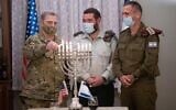 US Chairman of the Joint Chiefs of Staff Gen. Mark Milley lights a menorah on the eighth night of the Hannukah holiday alongside Cpt. Josh Gerstein and IDF Chief of Staff Aviv Kohavi in army headquarters in Tel Aviv on December 17, 2020. (Israel Defense Forces)
