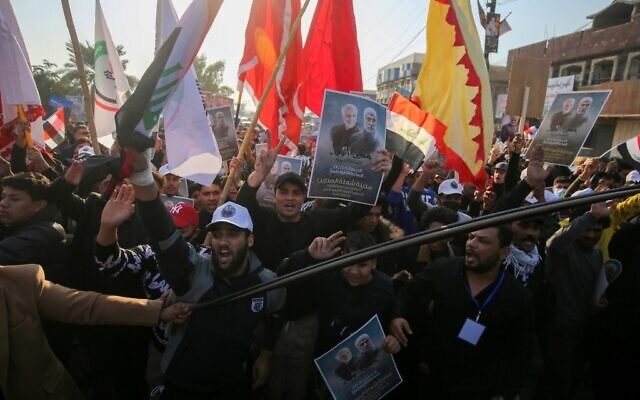 Iraqi supporters of the Hashed al-Shaabi paramilitary carry portraits of Iraqi commander Abu Mahdi al-Muhandis and Iranian Revolutionary Guards commander Qasem Soleimani during a demonstration in Baghdad's western Shoala neighborhood on January 1, 2021, demanding the expulsion of US forces from Iraq and calling for revenge for the killing of al-Muhandis and Soleimani, ahead of the January 3 anniversary of the US drone strike (AHMAD AL-RUBAYE / AFP) Iraqi supporters of the Hashed al-Shaabi paramilitary carry portraits of Iraqi commander Abu Mahdi al-Muhandis and Iranian Revolutionary Guards commander Qasem Soleimani during a demonstration in Baghdad's western Shoala neighborhood on January 1, 2021, demanding the expulsion of US forces from Iraq and calling for revenge for the killing of al-Muhandis and Soleimani, ahead of the January 3 anniversary of the US drone strike (AHMAD AL-RUBAYE / AFP)