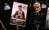 People carry portraits of late Iraqi commander Abu Mahdi al-Muhandis and Iranian commander Qasem Soleimani at Baghdad Airport, in Baghdad on January 2, 2021, at the site of their killing. (AHMAD AL-RUBAYE / AFP)