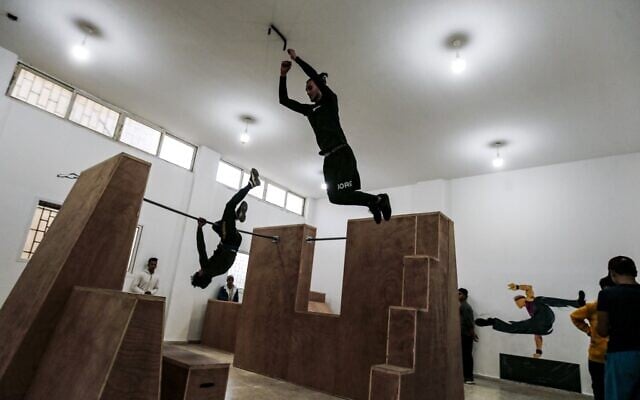 Palestinian youths train at the Wallrunners Parkour Academy's training facility in Gaza City on December 28, 2020. (MAHMUD HAMS / AFP)