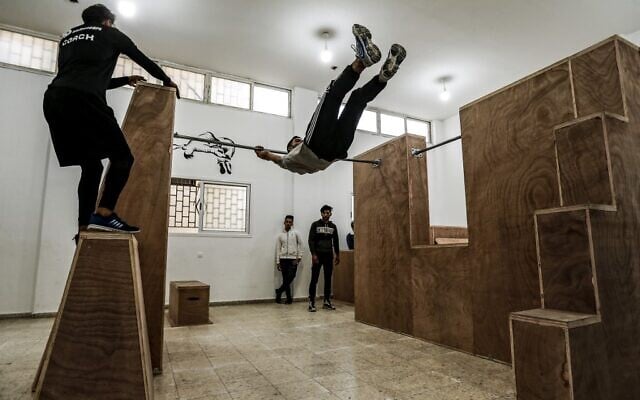 Mohamed Aliwa, a Palestinian youth whose leg was amputated near the knee in 2018 after he was injured during clashes with the   Israeli army in violent protests along the border with Israel, shows off his parkour skills despite his disability and while on crutches in Gaza City on January 4, 2021. (MAHMUD HAMS / AFP)