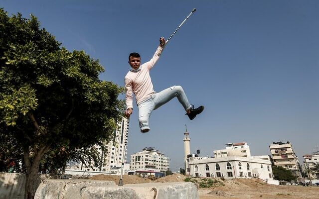 Mohamed Aliwa, a Palestinian youth whose leg was amputated near the knee in 2018 after he was injured during clashes with the Israeli army in violent protests along the border with Israel, shows off his parkour skills despite his disability in Gaza City on January 4, 2021. (MAHMUD HAMS / AFP)