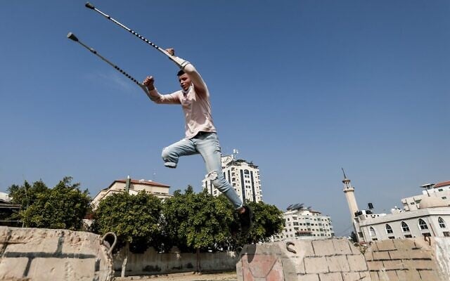 Mohamed Aliwa, a Palestinian youth whose leg was amputated near the knee in 2018 after he was injured during clashes with the   Israeli army in violent protests along the border with Israel, shows off his parkour skills despite his disability and while on crutches in Gaza City on January 4, 2021. (MAHMUD HAMS / AFP)