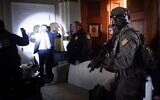 Congress staffers hold up their hands while Capitol Police Swat teams check everyone in the room as they secure the floor of Trump suporters in Washington, DC on January 6, 2021.  (Olivier DOULIERY / AFP)