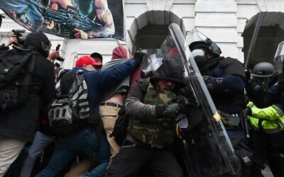 In this file photo taken on January 6, 2021, riot police push back a crowd of supporters of US President Donald Trump after they stormed the Capitol building in Washington, DC. (Photo by ROBERTO SCHMIDT / AFP)