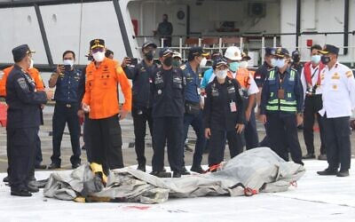 Rescue workers inspect recovered debris at the port in Jakarta on January 10, 2021, during the search operation for Sriwijaya Air flight SJY182 which crashed after takeoff from Jakarta on January 9. (Dany Krisnadhi / AFP)