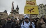 A demonstrator dressed in a costume of prisoner holds a banner reading the word 'Untermensch' (sub-human) referring to a Nazi term attends the protest against COVID-19 government measures on January 10, 2021, in the old Town Square in Prague. (Michal Cizek / AFP)