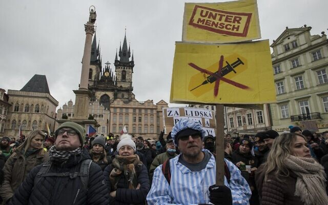 A demonstrator dressed in a costume of prisoner holds a banner reading the word 'Untermensch' (sub-human) referring to a Nazi term attends the protest against COVID-19 government measures on January 10, 2021, in the old Town Square in Prague. (Michal Cizek / AFP) A demonstrator dressed in a costume of prisoner holds a banner reading the word 'Untermensch' (sub-human) referring to a Nazi term attends the protest against COVID-19 government measures on January 10, 2021, in the old Town Square in Prague. (Michal Cizek / AFP)