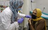 A Palestinian resident of East Jerusalem's Beit Hanina neighborhood gets vaccinated against the coronavirus at a Clalit Health Services clinic there, on January 12, 2021. (Ahmad Gharabli/AFP)