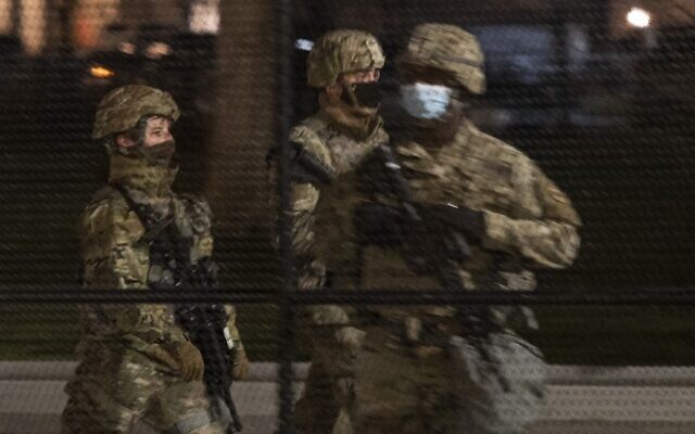 Two members of the US National Guard patrol around the US Capitol as another stands at his post in Washington, DC, on January 12, 2021. (ANDREW CABALLERO-REYNOLDS / AFP) Two members of the US National Guard patrol around the US Capitol as another stands at his post in Washington, DC, on January 12, 2021. (ANDREW CABALLERO-REYNOLDS / AFP)