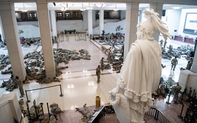 Members of the National Guard rest in the Capitol Visitors Center on Capitol Hill in Washington, DC, January 13, 2021, ahead of an expected House vote impeaching US President Donald Trump.  (SAUL LOEB / AFP)