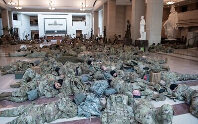Members of the National Guard rest in the Capitol Visitors Center on Capitol Hill in Washington, DC, January 13, 2021, ahead of an expected House vote impeaching US President Donald Trump. (SAUL LOEB / AFP)
