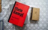 The Polish academic edition of Adolf Hitler's 'Mein Kampf' (L) is seen next to an original edition of the book from 1942 (R) on the table of Eugeniusz Cezary Król, author of the translation and historical commentary of the academic edition, in his flat in Warsaw, on January 15, 2021. (Photo by Wojtek RADWANSKI / AFP)