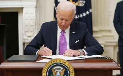US President Joe Biden signs executive orders as part of his administration's COVID-19 response, in the State Dining Room of the White House in Washington, on January 21, 2021. (Mandel Ngan/AFP)