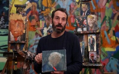 Israeli painter Iddo Markus speaks during an interview at his studio, surrounded by his paintings of former US president Donald Trump, in the northern port city of Haifa, on January 22, 2021 (Emmanuel DUNAND / AFP)
