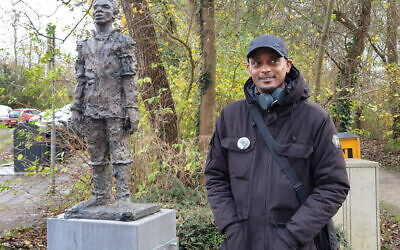 Sergio Berrenstein stands next to the statue of Elieser at the entrance to the Jewish cemetery in Ouderkerk aan de Amstel, the Netherlands, November 20, 2020. (Cnaan Liphshiz/ JTA)