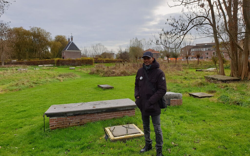 Sergio Berrenstein stands next to the grave of Elieser and his master at the entrance to the Jewish cemetery in Ouderkerk aan de Amstel, the Netherlands, November 20, 2020. (Cnaan Liphshiz/ JTA)