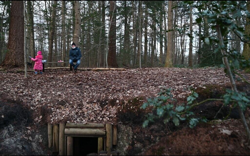 A Dutch child plays near her grandfather atop a reconstructed dugout for Jews in hiding in Nieuwlande, the Netherlands on January 25, 2021. (Cnaan Liphshiz/ JTA)
