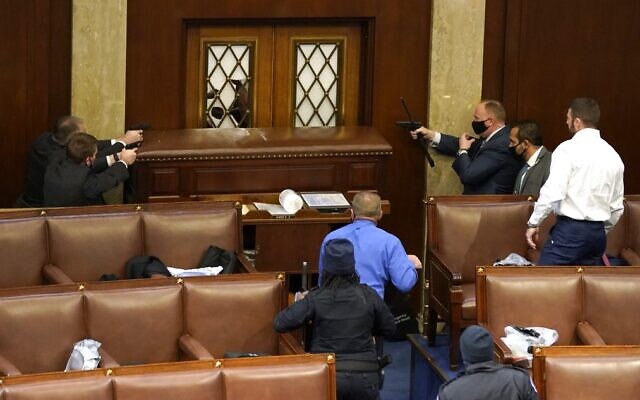US Capitol police officers point their guns at a door that was vandalized in the House Chamber during a joint session of Congress on January 6, 2021, in Washington. (Drew Angerer/Getty Images/AFP) US Capitol police officers point their guns at a door that was vandalized in the House Chamber during a joint session of Congress on January 6, 2021, in Washington. (Drew Angerer/Getty Images/AFP)