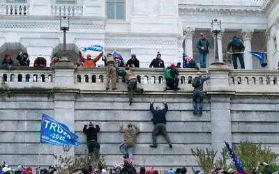 Supporters of US President Donald Trump climb the west wall of the the US Capitol in Washington, January 6, 2021. (Jose Luis Magana/AP)