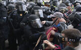 Capitol police officers in riot gear push back demonstrators who try to break a door of the U.S. Capitol in Washington, on January 6, 2021. (Jose Luis Magana/AP)