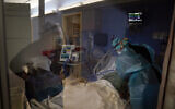 Registered nurses Kyanna Barboza, right, tends to a COVID-19 patient as Kobie Walsh puts on her PPE at St. Joseph Hospital in Orange, California, January 7, 2021. (AP/Jae C. Hong)