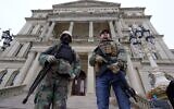 In this Jan. 6, 2021 file photo, armed men stand on the steps at the State Capitol after a rally in support of President Donald Trump in Lansing, Michigan (AP Photo/Paul Sancya, File)