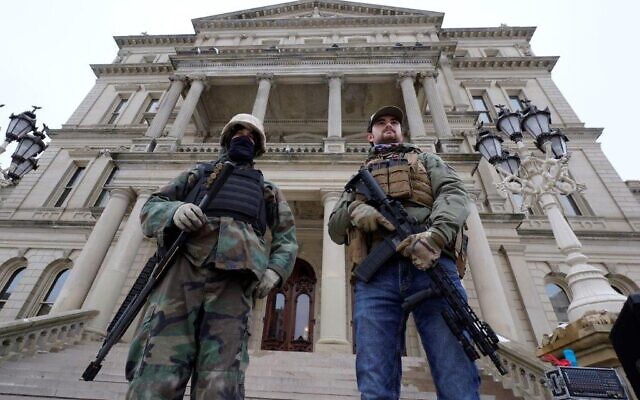 In this Jan. 6, 2021 file photo, armed men stand on the steps at the State Capitol after a rally in support of President Donald Trump in Lansing, Michigan (AP Photo/Paul Sancya, File) In this Jan. 6, 2021 file photo, armed men stand on the steps at the State Capitol after a rally in support of President Donald Trump in Lansing, Michigan (AP Photo/Paul Sancya, File)