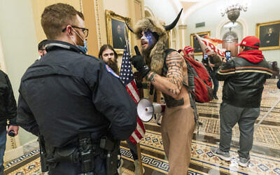 Supporters of US President Donald Trump, including an Arizona man wearing a fur hat with horns, are confronted by US Capitol Police officers outside the Senate Chamber inside the Capitol in Washington, January 6, 2021. (AP Photo/Manuel Balce Ceneta, File)