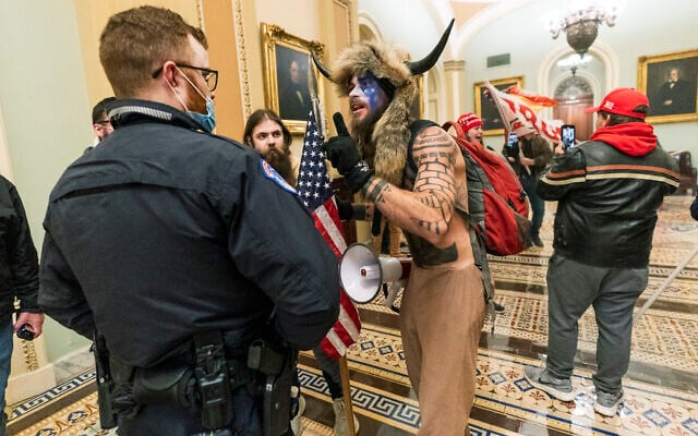 Supporters of President Donald Trump are confronted by US Capitol Police officers outside the Senate Chamber inside the Capitol in Washington, January 6, 2021. Jacob Anthony Chansley, who also goes by the name Jake Angeli (center), was taken into custody on January 9. (AP Photo/Manuel Balce Ceneta, File) Supporters of President Donald Trump are confronted by US Capitol Police officers outside the Senate Chamber inside the Capitol in Washington, January 6, 2021. Jacob Anthony Chansley, who also goes by the name Jake Angeli (center), was taken into custody on January 9. (AP Photo/Manuel Balce Ceneta, File)