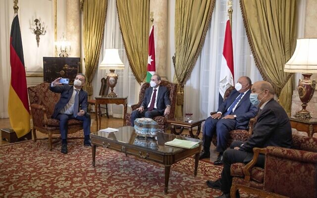 From left to right, German Foreign Minister Heiko Maas, takes a photo with his cellphone of journalists, during a meeting with Jordanian Foreign Minister Ayman Safadi, Egyptian Foreign Minister Sameh Shoukry, and French Foreign Minister Jean-Yves Le Drian, ahead of a press conference at Tahrir Palace, in Cairo, Egypt, January 11, 2021. (AP Photo/Nariman El-Mofty) From left to right, German Foreign Minister Heiko Maas, takes a photo with his cellphone of journalists, during a meeting with Jordanian Foreign Minister Ayman Safadi, Egyptian Foreign Minister Sameh Shoukry, and French Foreign Minister Jean-Yves Le Drian, ahead of a press conference at Tahrir Palace, in Cairo, Egypt, January 11, 2021. (AP Photo/Nariman El-Mofty)