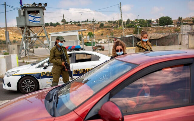 Israeli soldiers check the ID of a Palestinian woman at the Tapuach junction checkpoint next to the West Bank city of Nablus, June 30, 2020. (AP Photo/Oded Balilty, File) Israeli soldiers check the ID of a Palestinian woman at the Tapuach junction checkpoint next to the West Bank city of Nablus, June 30, 2020. (AP Photo/Oded Balilty, File)