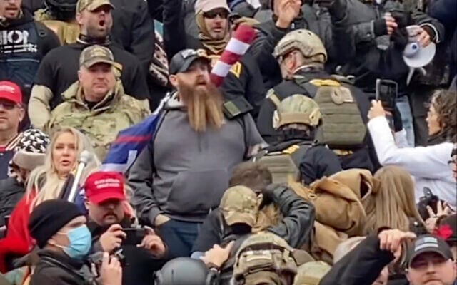 In this Jan. 6, 2021 image from video provided by Robyn Stevens Brody, a line of men wearing helmets and olive drab body armor walk up the marble stairs outside the US Capitol in Washington in an orderly single-file line, each man holding the jacket collar of the man ahead (Robyn Stevens Brody via AP) In this Jan. 6, 2021 image from video provided by Robyn Stevens Brody, a line of men wearing helmets and olive drab body armor walk up the marble stairs outside the US Capitol in Washington in an orderly single-file line, each man holding the jacket collar of the man ahead (Robyn Stevens Brody via AP)