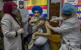 A hospital staff member receives a COVID-19 vaccine at a government Hospital in Srinagar, Indian controlled Kashmir, January 16, 2021. (AP Photo/ Dar Yasin)