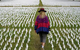 Artist Suzanne Brennan Firstenberg walks among thousands of white flags planted in remembrance of Americans who have died of COVID-19, near Robert F. Kennedy Memorial Stadium in Washington, October 27, 2020. (AP Photo/Patrick Semansky, File)