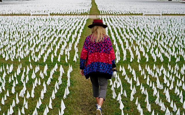 Artist Suzanne Brennan Firstenberg walks among thousands of white flags planted in remembrance of Americans who have died of COVID-19, near Robert F. Kennedy Memorial Stadium in Washington, October 27, 2020. (AP Photo/Patrick Semansky, File) Artist Suzanne Brennan Firstenberg walks among thousands of white flags planted in remembrance of Americans who have died of COVID-19, near Robert F. Kennedy Memorial Stadium in Washington, October 27, 2020. (AP Photo/Patrick Semansky, File)