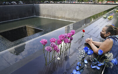 A mourner prays at the National September 11 Memorial and Museum in New York, September 11, 2020. (John Minchillo/AP)