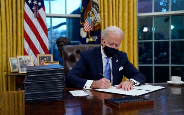 US President Joe Biden signs his first executive order in the Oval Office of the White House on January 20, 2021, in Washington. (AP Photo/Evan Vucci) US President Joe Biden signs his first executive order in the Oval Office of the White House on January 20, 2021, in Washington. (AP Photo/Evan Vucci)