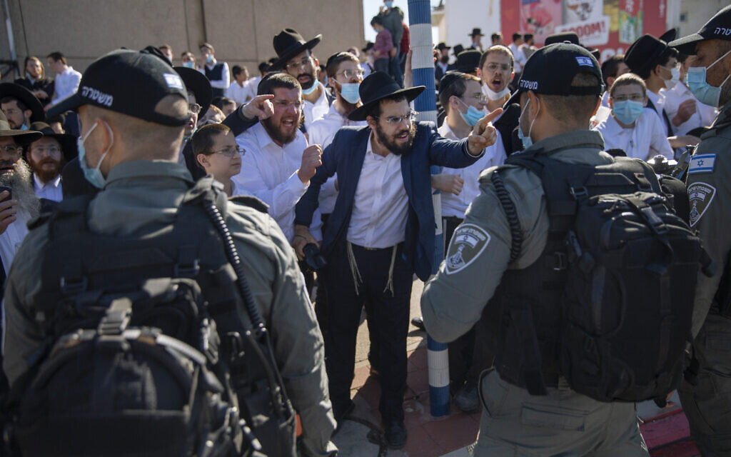 Illustrative: Ultra-Orthodox Jews argue with Israeli border police officers during a protest over the coronavirus lockdown restrictions, in Ashdod, January 24, 2021. (AP/Oded Balilty) Illustrative: Ultra-Orthodox Jews argue with Israeli border police officers during a protest over the coronavirus lockdown restrictions, in Ashdod, January 24, 2021. (AP/Oded Balilty)