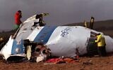 In this December 22, 1988 file photo police and investigators look at what remains of the flight deck of Pan Am 103 in a field in Lockerbie, Scotland. In 1988, 270 people were killed when a terrorist bomb exploded aboard a Pam Am Boeing 747 over Lockerbie, Scotland, sending wreckage crashing to the ground. (AP Photo/File)
