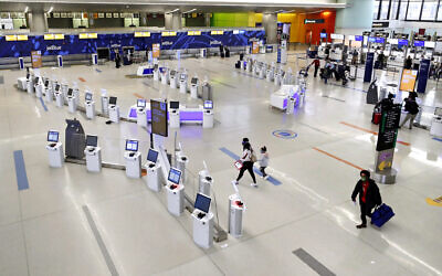 Travelers walk through the nearly empty JetBlue terminal at Logan Airport, Friday Nov. 20, 2020, in Boston. (AP Photo/Michael Dwyer)