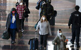 Travelers wearing masks walk to and from their planes at Ronald Reagan Washington National Airport, Nov. 24, 2020, in Arlington, Virginia (AP Photo/Jacquelyn Martin)