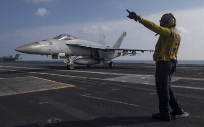 In this photo released by the U.S. Navy, Aviation Boatswain's Mate 3rd Class Marnell Maglasang, from La Puente, Calif., directs an F/A-18E Super Hornet on the flight deck of the aircraft carrier USS Nimitz in the Arabian Sea, Friday Nov. 27, 2020. The Nimitz returned to the Mideast in a move to support the drawdown of troops in Afghanistan and Iraq according to the Pentagon. (Mass Communication Specialist 3rd Class Cheyenne Geletka/U.S. Navy via AP)