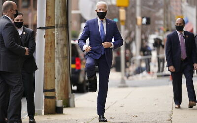 President-elect Joe Biden, wearing a medical boot, raises his leg as he enters The Queen theater, December 1, 2020, in Wilmington, Delaware. (AP Photo/Andrew Harnik)