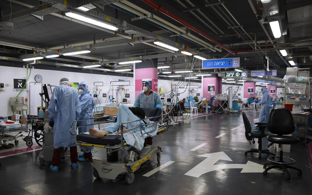 Medical personnel wearing protective equipment treat COVID-19 patients in an intensive care ward that has been converted from underground parking, at Rambam Hospital in the northern city of Haifa, December 15, 2020. (AP Photo/Oded Balilty) Medical personnel wearing protective equipment treat COVID-19 patients in an intensive care ward that has been converted from underground parking, at Rambam Hospital in the northern city of Haifa, December 15, 2020. (AP Photo/Oded Balilty)