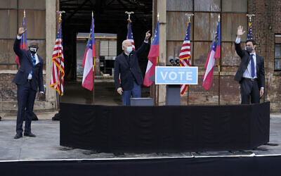 President-elect Joe Biden, center, acknowledge supporters at the end of a drive-in rally for Georgia Democratic candidates for US Senate Raphael Warnock, left, and Jon Ossoff, Dec. 15, 2020, in Atlanta. (AP Photo/Patrick Semansky)