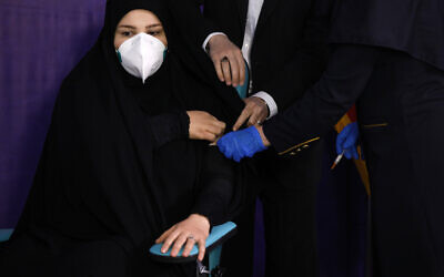 Tayebeh Mokhber is injected with the Coviran coronavirus vaccine produced by Shifa Pharmed, part of a state-owned pharmaceutical conglomerate, in a ceremony in Tehran, Iran on December 29, 2020. (AP/Aref Taherkenareh)