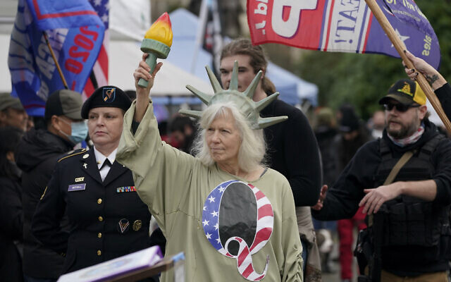 A person dressed as Lady Liberty wears a shirt with the letter Q, referring to QAnon, as protesters take part in a protest at the Capitol in Olympia, Washington, against the counting of electoral votes in Washington, DC, affirming President-elect Joe Biden's victory, January 6, 2021. (Ted S. Warren/AP) A person dressed as Lady Liberty wears a shirt with the letter Q, referring to QAnon, as protesters take part in a protest at the Capitol in Olympia, Washington, against the counting of electoral votes in Washington, DC, affirming President-elect Joe Biden's victory, January 6, 2021. (Ted S. Warren/AP)